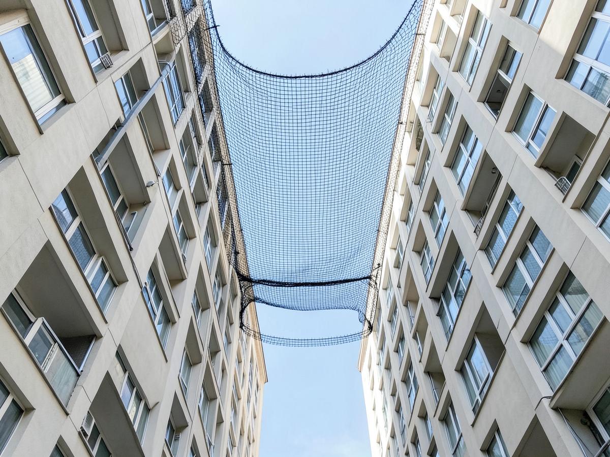 Bird net installed across a building duct shaft between two apartment towers in Maharashtra