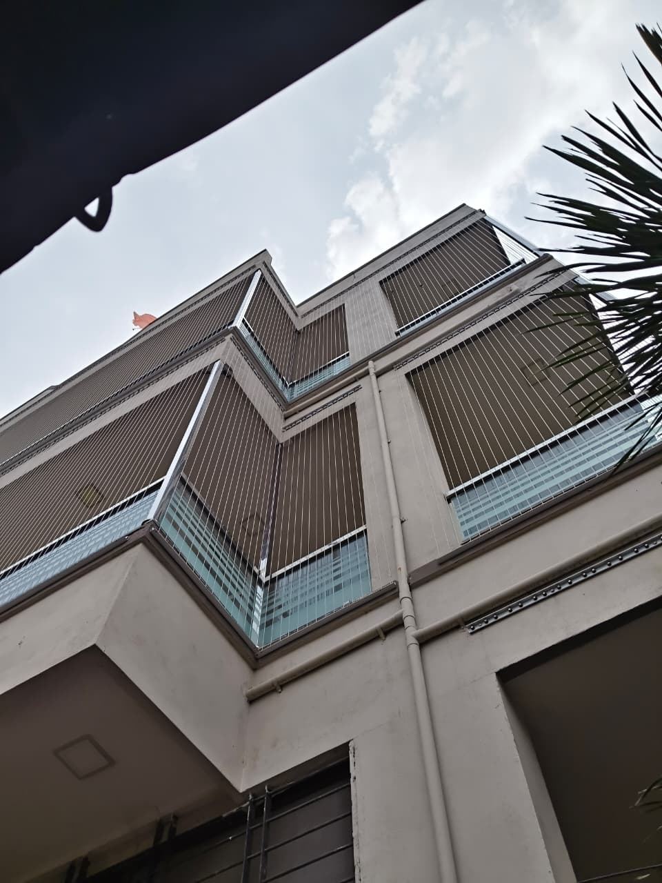 Invisible grills on stacked corner balconies seen from below