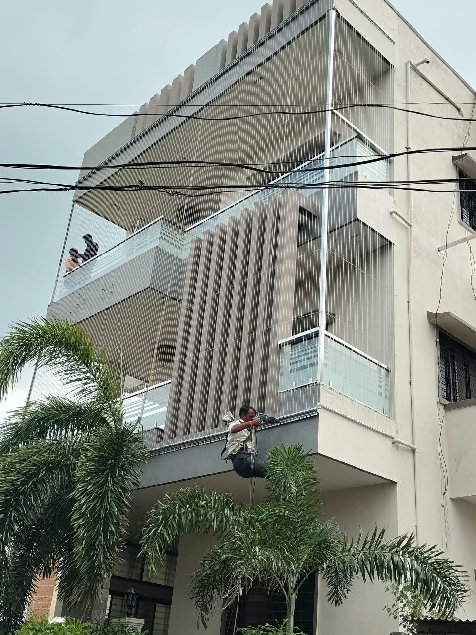 Invisible grill installation in progress on a home with installers on the facade
